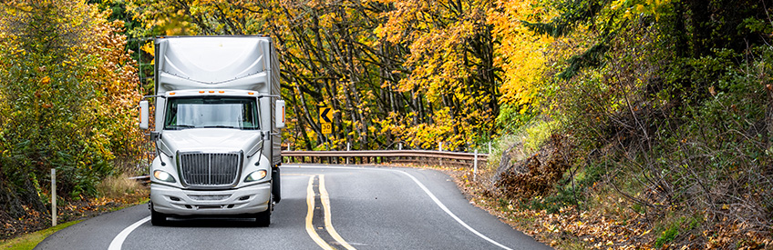 Tractor Trailer driving on winding mountain road 