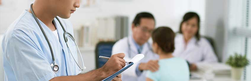 Medical assistant taking notes on clipboard