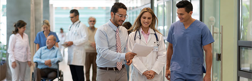 Hospital manager showing a document to doctor and nurse all smiling