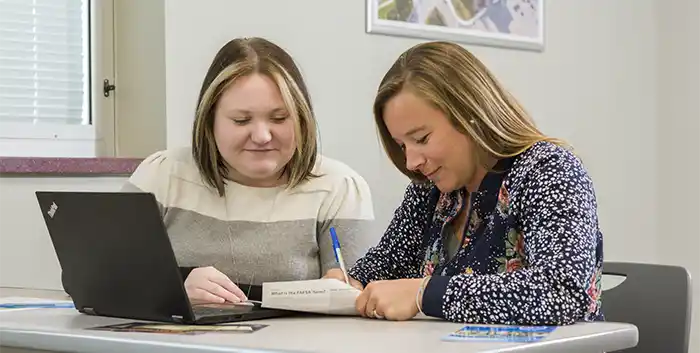 Smiling Cost and Aid staff at desk